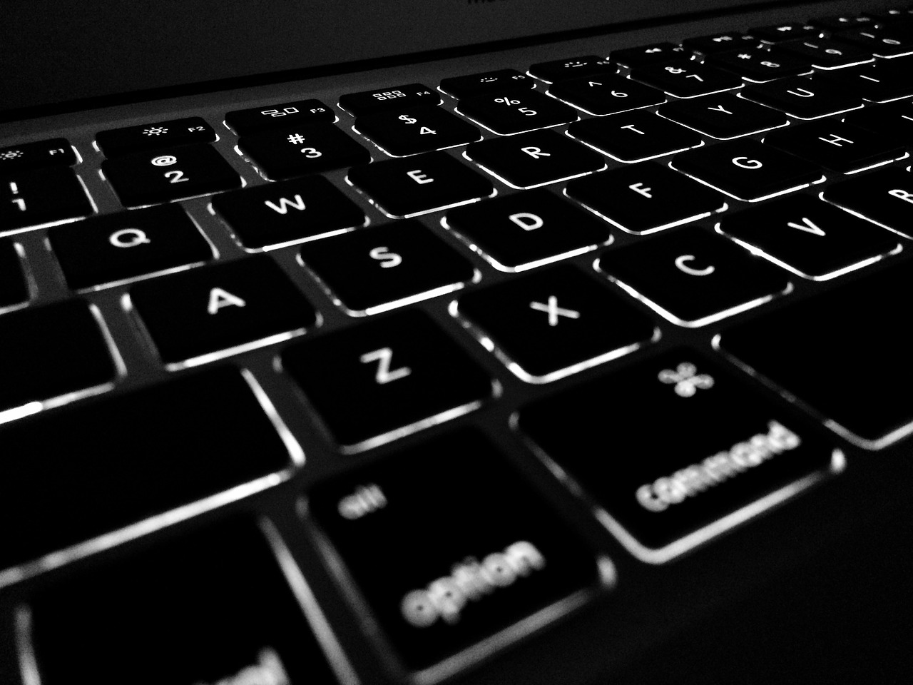 A imagem mostra um pedaço de teclado de computador, da cor preta. 