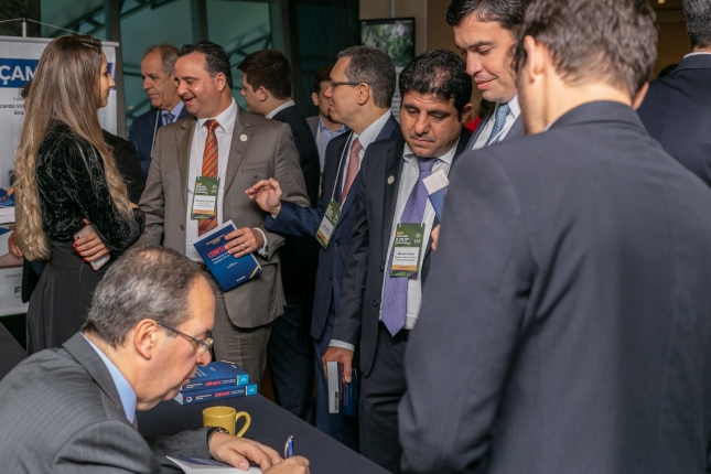 Min. Ricardo Villas Bôas Cueva signing the book that he coordinated with Prof. Ana Frazão